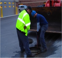 workers at sewer opening